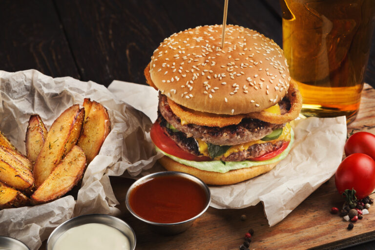 fast food burger and potatoes served with beer at restaurant