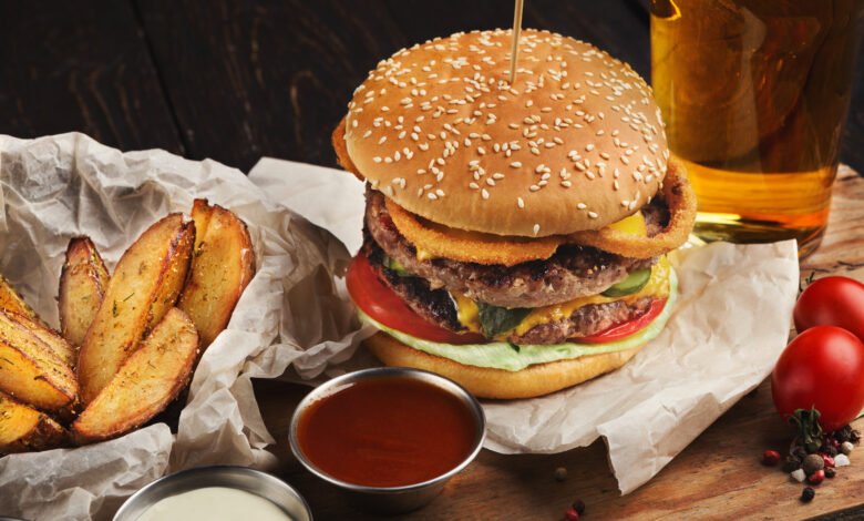 fast food burger and potatoes served with beer at restaurant